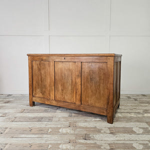 An early 20th-century antique pine chest with a hinged lift-up lid, two internal storage compartments and block feet. This wooden blanket box shows a country, farmhouse character with panelled sides and a waxed pine finish enhancing the natural grain and patina.