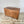 A large antique pine storage chest from the early 20th century, featuring a hinged lid, divided interior and simple block feet. The waxed pine surface highlights its cottage and farmhouse style, making it a robust wooden trunk for storing linens or household items.