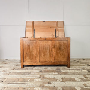 A large antique pine blanket chest featuring a hinged lid, divided interior and simple block feet. Finished in wax to enhance its warm pine tone, this wooden storage trunk has a country and cottage style feel, offering generous organised storage for linens, bedding or household essentials within its early 20th-century form.