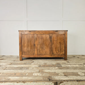 Large antique pine storage chest with block feet and paneled sides
