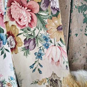 Antique-style floral bow hanging on a rustic green painted door.
