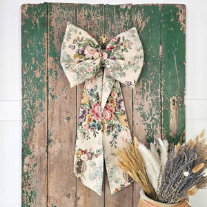 Bespoke floral bow with brass ring, enhancing a traditional home aesthetic.