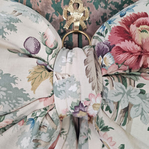 Handmade floral bow with vibrant flowers on a cream background.