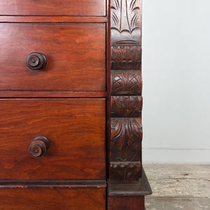 Tall wooden dresser with hand-carved leaf patterns on the pillars and sturdy bun feet.
