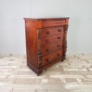 American walnut chest of drawers with deep storage drawers and hand-carved leaf motifs.
