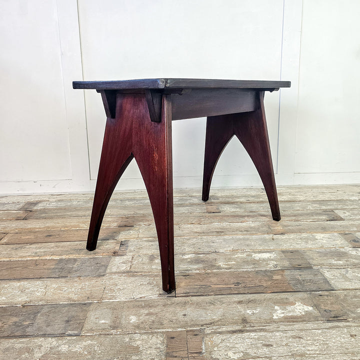 "Wax-sealed mahogany table with modern arched design."
