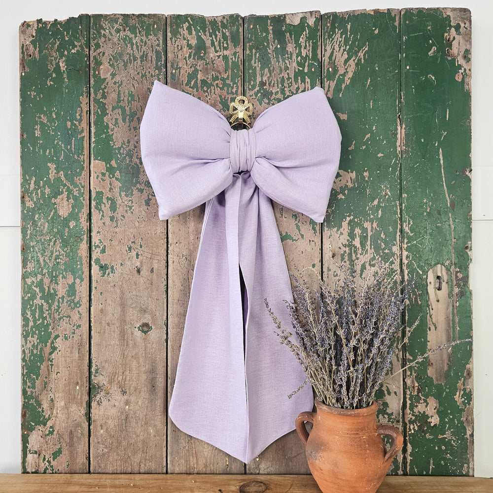 Soft lilac linen mix bow with a structured cushioned body.
