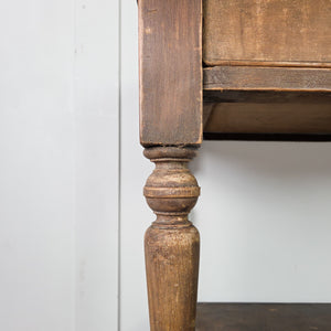 A Victorian rustic painted pine console table from the 19th century with two drawers set to the front, each fitted with wooden knobs. Raised on turned legs, the table includes a lower shelf below and retains its original painted surface throughout.
