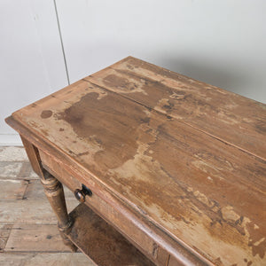 An antique Victorian rustic painted pine console table with two drawers to the front, wooden knobs and four turned legs. The table includes a lower shelf below and retains its original painted surface from the 19th century.