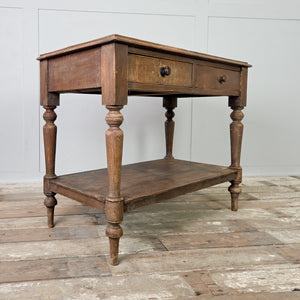 A 19th century antique country painted pine side table with two drawers fitted with wooden knobs and supported by four turned legs. The table includes a lower shelf beneath and retains its original painted finish across the frame and legs.