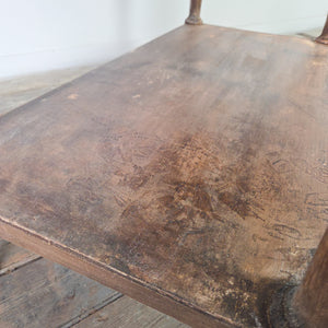 A 19th century country painted pine side table featuring two drawers with wooden knobs, raised on four turned legs with a lower shelf below. The table retains its original painted finish throughout the piece.