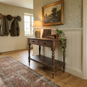 A Victorian antique rustic painted pine console table from the 19th century, featuring two drawers fitted with wooden knobs and raised on four turned legs. The table includes a lower shelf beneath for additional storage and retains its original painted finish throughout.