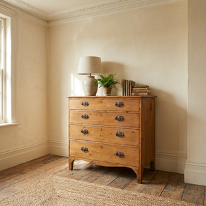 Antique Georgian pine chest of drawers from the early 19th century, with four graduating full-width drawers, decorative brass plate drop handles, a shaped lower apron and ogee style feet.
