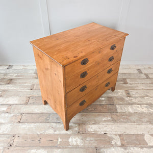 Antique Georgian pine four drawer chest with full-width drawers, decorative brass plate drop handles and a shaped lower apron, suitable for bedroom drawers or sideboard use.