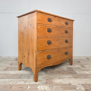 Early 19th century pine chest of drawers from the Georgian period, featuring four full-width drawers, brass plate drop handles and a shaped apron above ogee style feet.