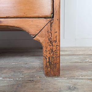 Georgian antique pine chest of drawers with a four drawer layout, decorative brass plate drop handles and a shaped lower apron, finished in rustic pine wax.