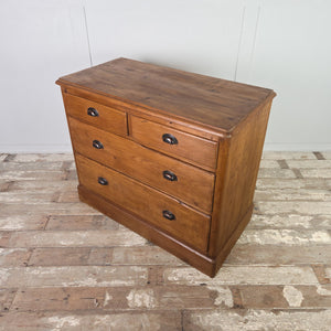 Four-drawer antique pine chest of drawers with a two-over-two drawer layout, later-added cup handles that suit the piece, and a clean plinth base finished in pine wax.
