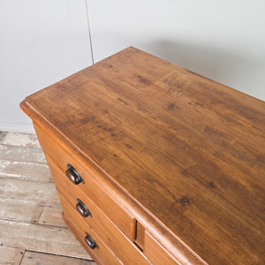 Antique pine storage chest with four drawers arranged two over two, later-added metal cup handles, and a plain plinth base, finished with a traditional pine wax.
