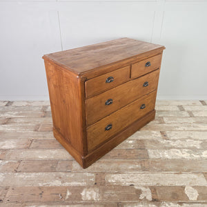 Rustic antique pine chest of drawers featuring four drawers in a two-over-two configuration, raised on a plain plinth base and finished with pine wax.
