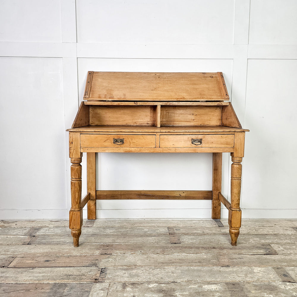 Antique pine writing table with lift-up top and drawer storage
