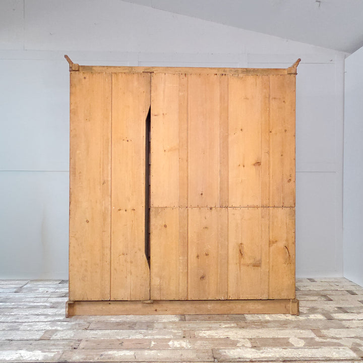 19th century Victorian pine wardrobe with a mirrored centre door, two side doors, and internal drawers. This antique pine triple wardrobe provides hanging space, drawers, and a storage compartment within a classic Victorian design. A solid and functional example of antique pine furniture and practical bedroom storage.