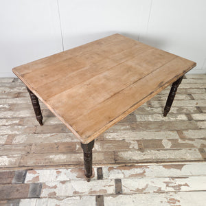 This farmhouse table dates from the 19th century and is built with a broad rectangular beech top over a black painted base. Raised on turned legs, it includes two drawers at either end, each fitted with turned wooden knobs.