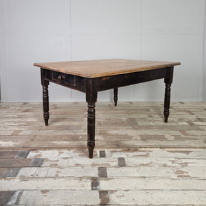 A 19th century farmhouse kitchen table with a wide rectangular hardwood top and a painted base raised on turned legs. The pale beech top has a moulded edge, and the two drawers at either end are practical for storing smaller kitchen items.