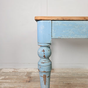 A Victorian pine table dating from the 19th century with a scrubbed pine top and a painted base in a soft powder blue. Raised on turned legs with a single drawer, it is suitable for use as a kitchen or dining table.