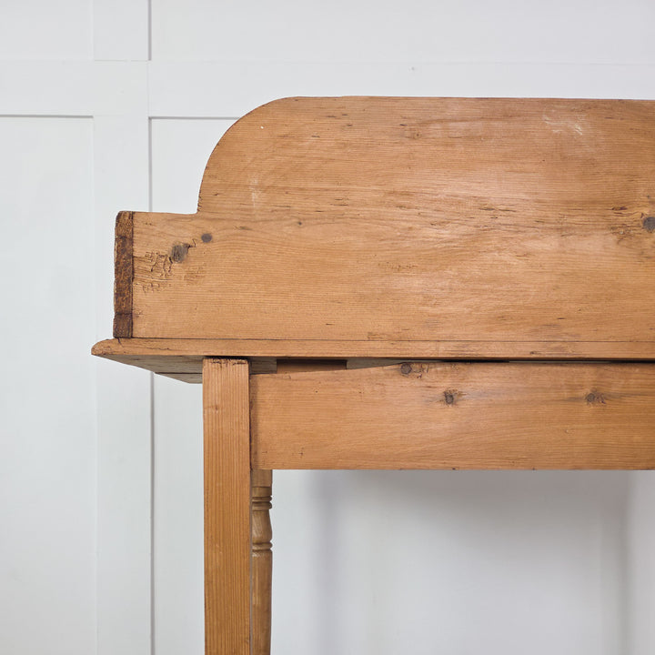 A 19th-century Victorian pine washstand with a gallery back and turned front legs, finished in wax to enhance the natural patina. A versatile rustic piece in farmhouse or country style, suitable as a side table or small dressing table.