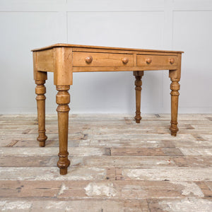 A 19th-century antique pine console table or desk with two drawers and turned legs, finished in wax to enrich the wood’s tone. A versatile farmhouse-style piece for hallway or study.