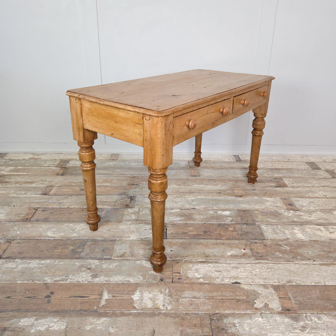 Antique pine desk or console table with a honey-toned waxed finish, turned legs and simple wooden knobs. A charming 19th-century piece for rustic interiors.