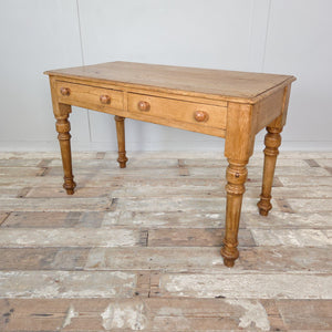 A 19th-century antique pine table with turned legs and twin drawers, finished in wax to highlight the grain. Works beautifully as a console or small writing desk.