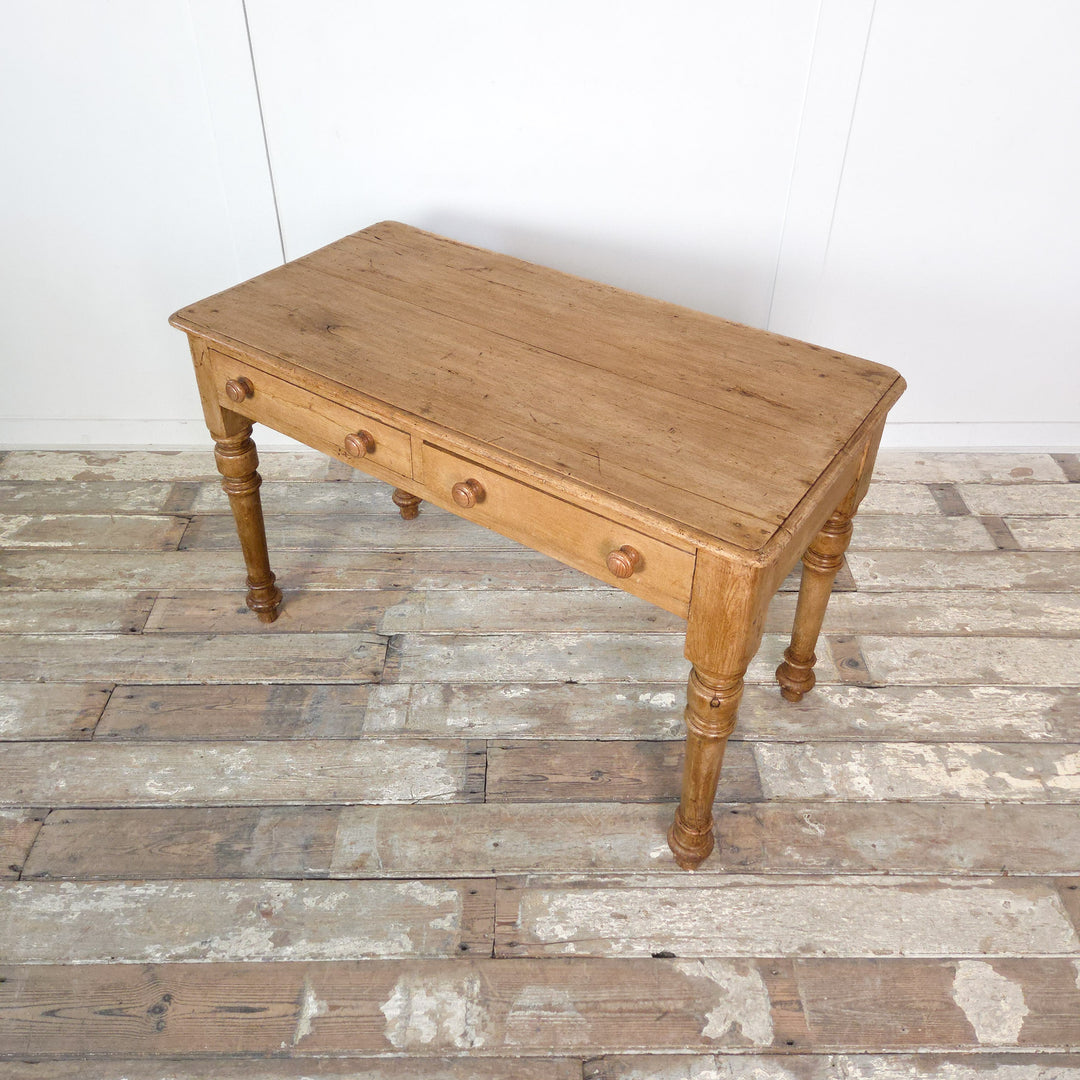 A 19th-century antique pine console table or desk with turned legs and twin drawers, finished in wax to enhance the wood’s warm tone. A versatile rustic piece perfect for country or farmhouse-style interiors.