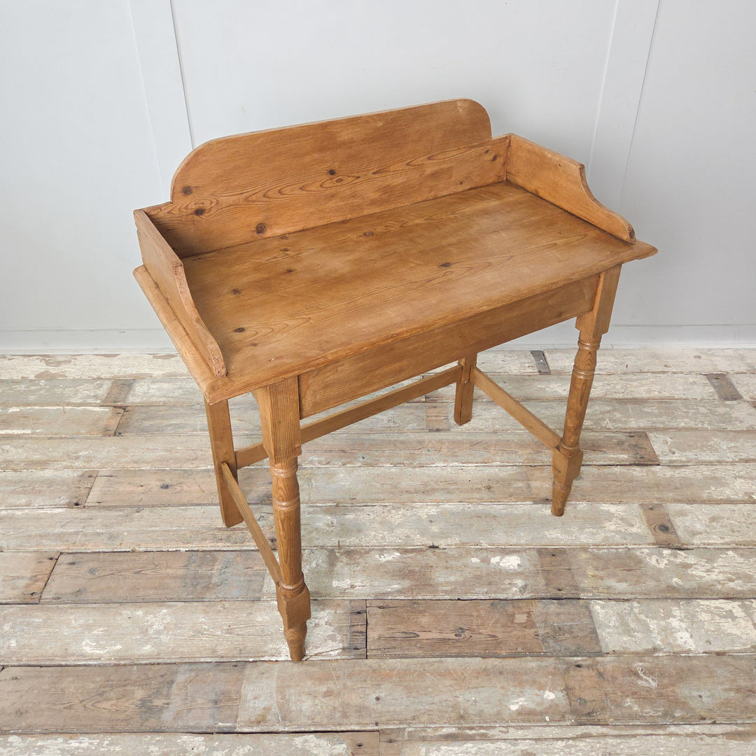 Victorian pine washstand from the 19th century with a gallery back, turned front legs and a waxed finish enhancing its colour and grain. A versatile antique for farmhouse, country or rustic settings.