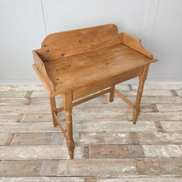 Victorian pine washstand from the 19th century with a gallery back, turned front legs and a waxed finish enhancing its colour and grain. A versatile antique for farmhouse, country or rustic settings.