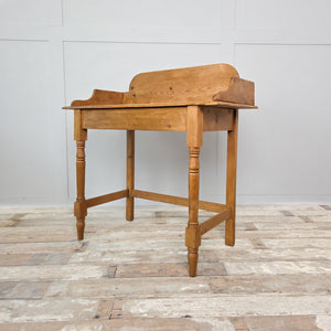 A rustic 19th-century Victorian pine washstand featuring a gallery back and turned front legs. Finished in wax to preserve the timber, this antique piece suits farmhouse, country house and classic interiors.