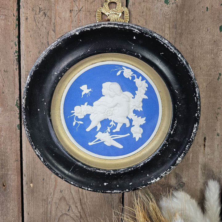 Hanging wall art with cherub design in plaster.
