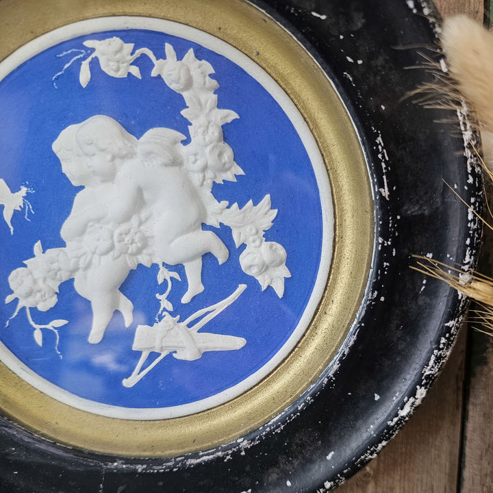 Round cherub plaque for home decor.
