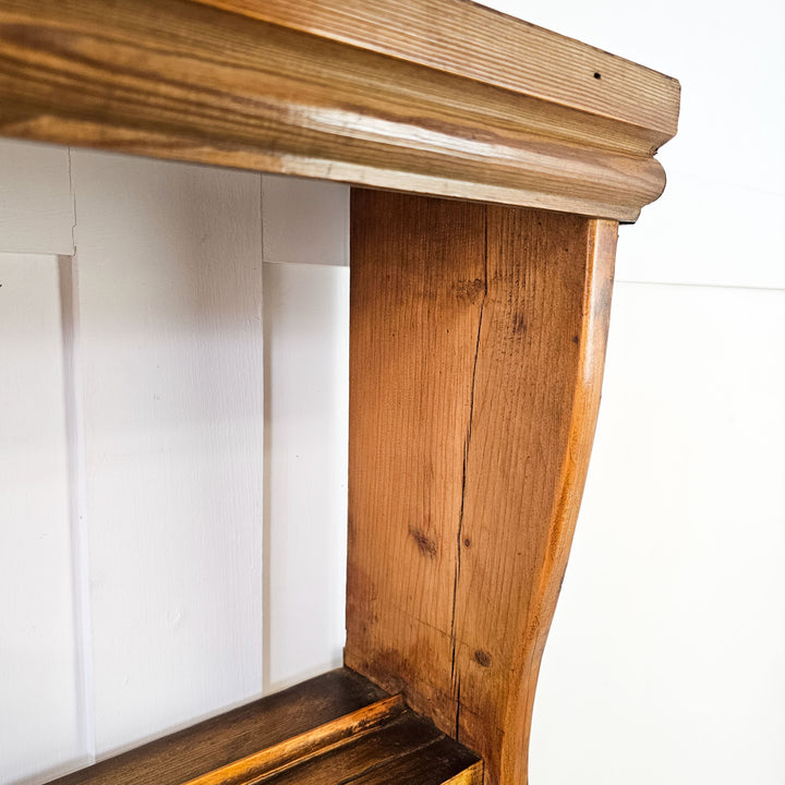 Antique wall-mounted pine rack with cup hooks.