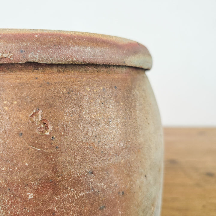 Rustic French confit pot with a sturdy handle, showcasing a beautiful glazed finish.