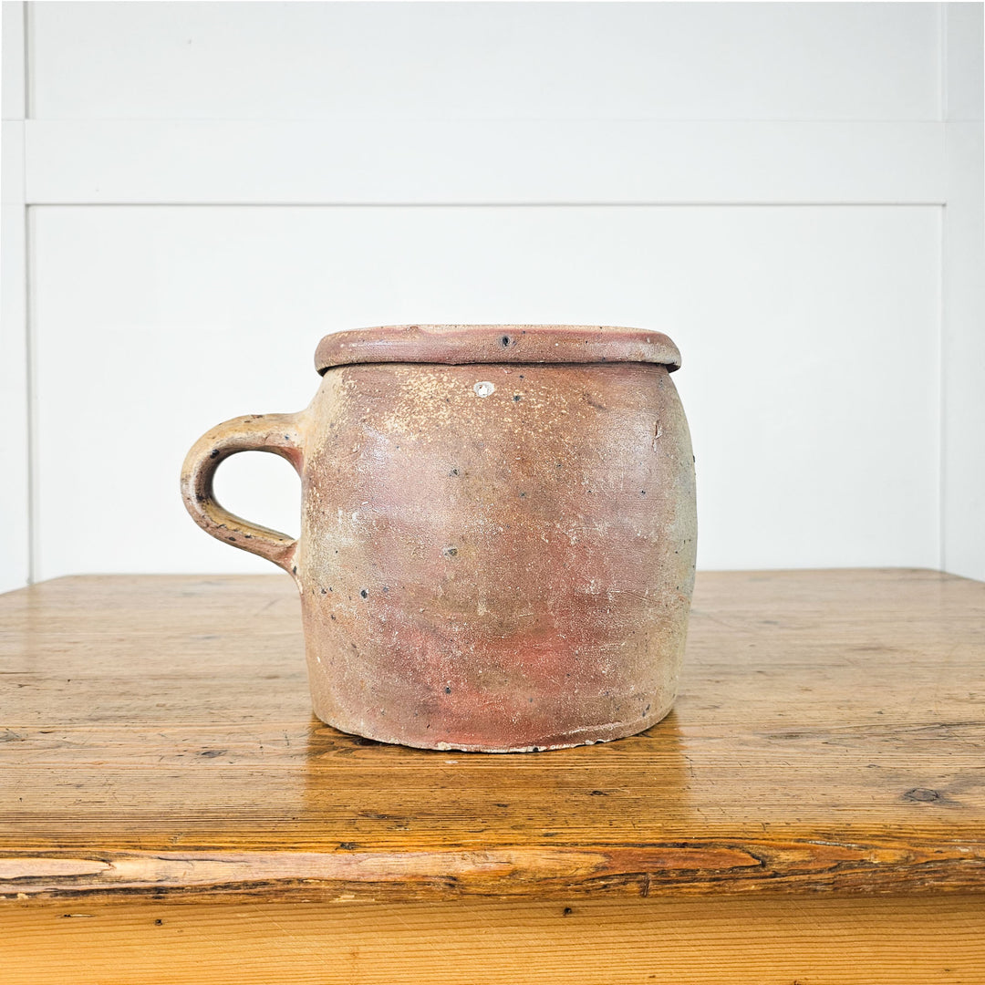 Side view of a 19th-century French pot with a soft glazed finish and handle.