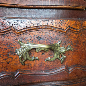 French walnut serpentine chest of drawers, 19th century. Constructed with four generously sized drawers, each with carved fronts, ornate brass handles, and escutcheons. Raised on carved legs, the walnut shows its naturally aged finish.