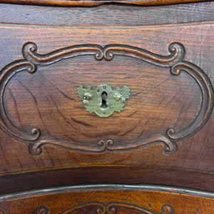 Antique French walnut serpentine commode from the 19th century. Constructed with four deep drawers, carved fronts, brass handles, and escutcheons, the piece is raised on short carved feet and retains the natural patina of aged walnut.