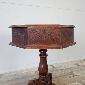 Antique oak occasional table with decorative carved motifs and tripod scrolled leg base
