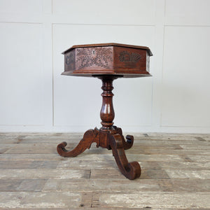 Victorian sewing table with carved laurel sprays and flower baskets across each side panel
