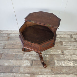 Antique oak tripod side table with octagonal hinged lid and decorative carving throughout
