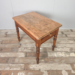 Rustic 19th century pine farmhouse table with a stripped pine top, softly rounded edges, and four turned legs. Includes a single drawer with original wooden knob, making it a practical country pine side table for a hallway, dining space, or farmhouse kitchen.