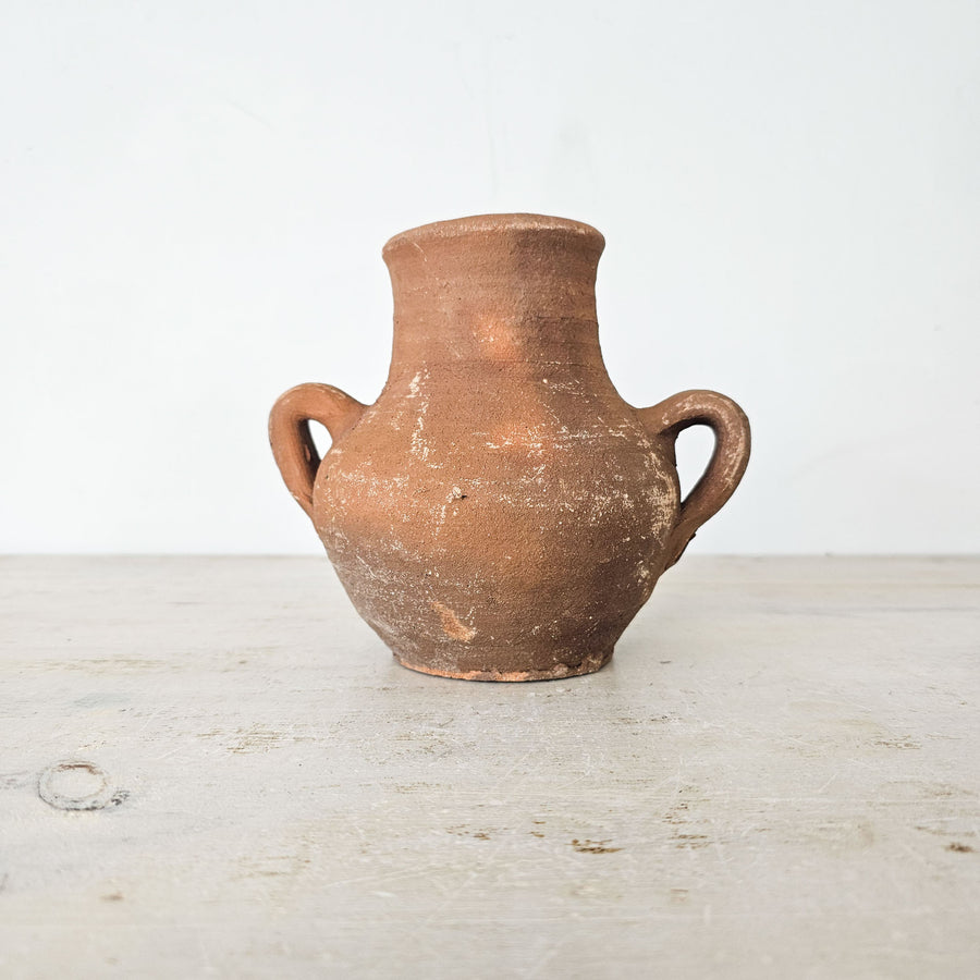 Handmade Turkish earthenware pot with rustic patina and small handles.