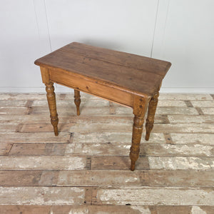 A small 19th-century pine farmhouse table featuring a two-plank top with smooth rounded edges, set on decorative turned legs that have been extended using newer timber. The simple apron completes this practical country-style table for hallway or kitchen use.