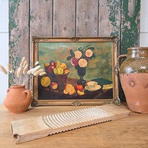 An oil on canvas still life painting from the late 19th century, depicting roses, fruit and ceramics, framed in a gilt frame with floral detail and signed by the artist in the lower right-hand corner.
